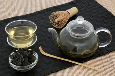 一位品茶师正在手持茶杯，专注品味着一杯清香的绿茶，展示了茶叶品味的专业与品位。